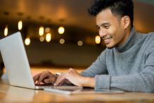 A man focused on his laptop searching for a job.