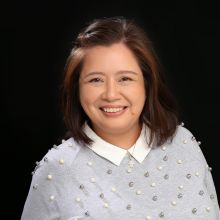 Smiling woman with shoulder-length brown hair wearing a sweater.