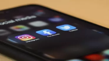 Smartphone displaying social media apps Instagram, Facebook, and Twitter.
