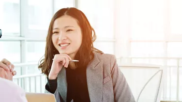 Two people having a conversation in a bright office setting.