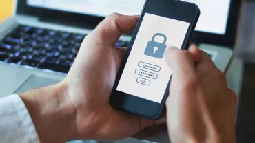 Person holding smartphone with a lock screen, displaying a security login.