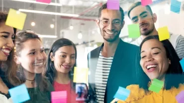 Diverse group of people brainstorming with sticky notes.