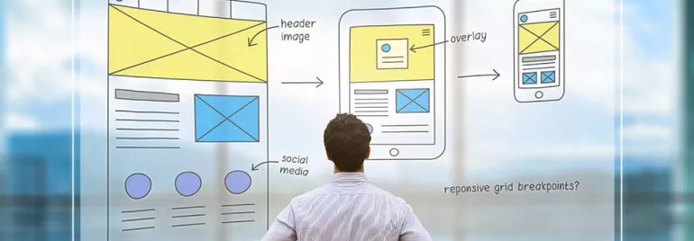 Person viewing a responsive web design sketch with desktop, tablet, and mobile layouts.