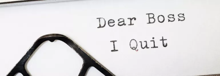 Typewriter with a typed note saying 'Dear Boss, I Quit.'