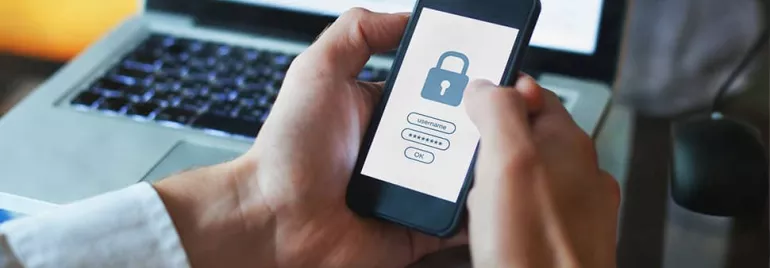 Person holding smartphone with a lock screen, displaying a security login.