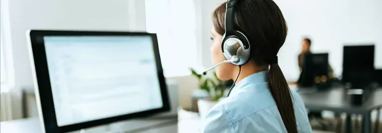 Person at computer wearing a headset, working in a call center.
