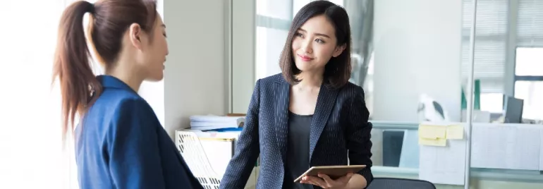 Two professionals having a discussion in a modern office setting.