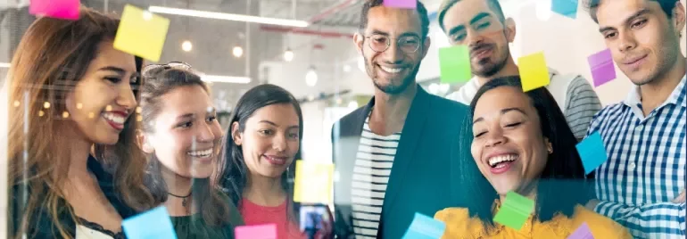 Diverse group of people brainstorming with sticky notes.