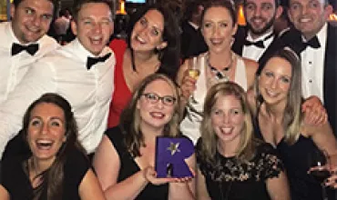 A group of people dressed formally, posing together at an event.