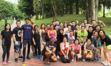 A large group of people posing together in a park.