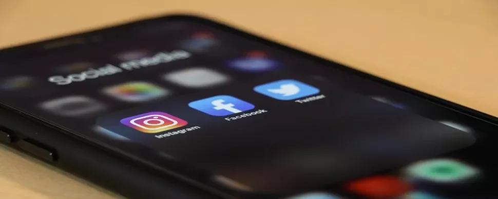 Smartphone displaying social media apps Instagram, Facebook, and Twitter.