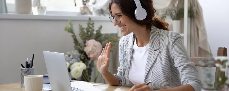Woman with headphones smiling during a video call