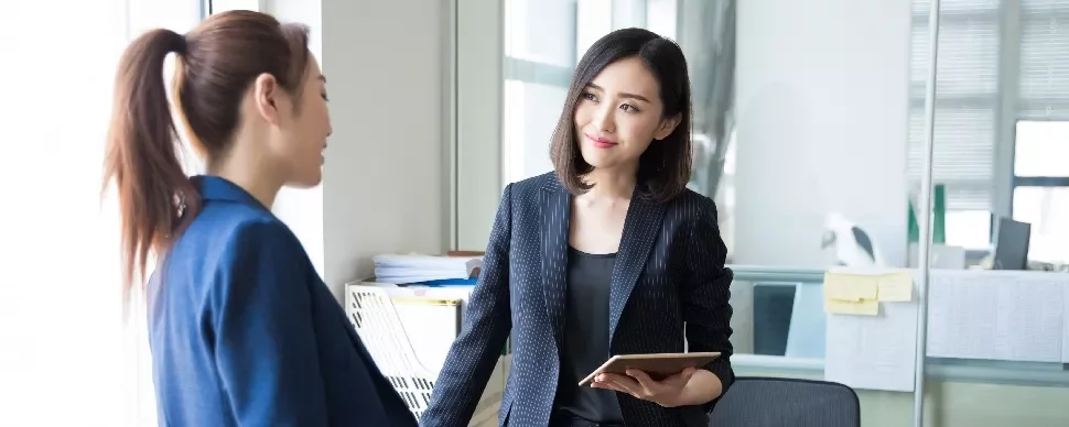 Two professionals having a discussion in a modern office setting.